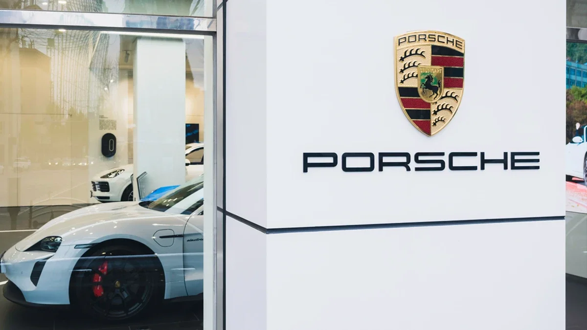 Porsche showroomunda sergilenen beyaz otomobiller ve Porsche logosu